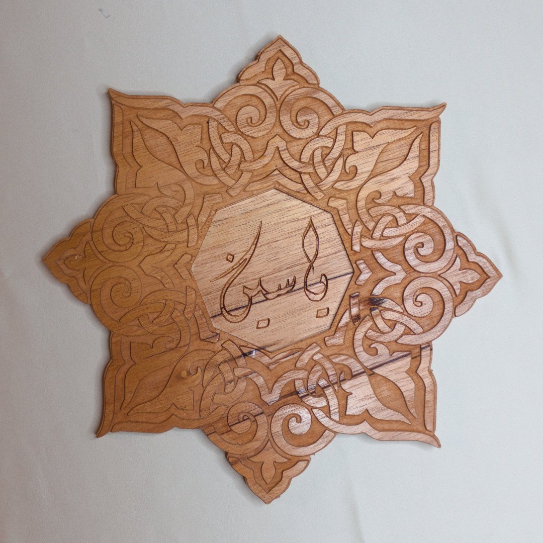 Customizable mahogany CNC-engraved wall art in an eight-pointed star shape with intricate floral patterns and personalized Arabic calligraphy.