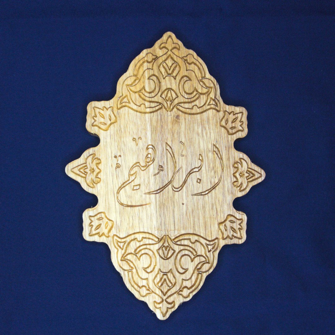 CNC engraved wooden wall art with Arabic calligraphy.